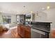 Modern kitchen with stainless steel appliances, island sink, and fireplace adjacent to a cozy living room area at 2053 Meade St, Denver, CO 80211