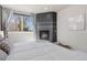 Comfortable bedroom with a cozy fireplace, neutral carpet, and ample natural light from the window at 2053 Meade St, Denver, CO 80211
