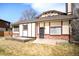 Spacious backyard with a two-story house featuring brick accents, a patio, and green grass at 6156 W Jefferson Ave, Denver, CO 80235