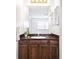 Cozy bathroom featuring a wood vanity and mirror, offering a functional and well-lit space at 6156 W Jefferson Ave, Denver, CO 80235