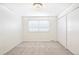 Bedroom features white walls, carpet, a window, and a closet with bi-fold doors at 6156 W Jefferson Ave, Denver, CO 80235