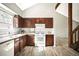 Well-lit kitchen with white countertops and dark wood cabinets, next to staircase at 6156 W Jefferson Ave, Denver, CO 80235