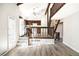 Bright living room showcasing stairs, wood floors, and a partial view of the kitchen with white appliances at 6156 W Jefferson Ave, Denver, CO 80235