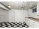 Basement kitchen with checkered floors, white cabinets, and dual basin stainless sink at 1545 N Harrison St, Denver, CO 80206