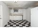 Basement kitchen with checkered floors, white cabinets, sink, and a refrigerator at 1545 N Harrison St, Denver, CO 80206