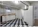 Basement kitchen with checkered floors, white cabinets, sink, refrigerator, and adjoining bath at 1545 N Harrison St, Denver, CO 80206