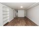 Spacious empty room boasting refinished hardwood flooring, built-in shelving, and fresh white paint at 1545 N Harrison St, Denver, CO 80206