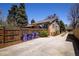 Fenced backyard reveals a brick house with access to a detached multi-car garage at 1545 N Harrison St, Denver, CO 80206