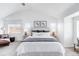 A sun-filled bedroom is complete with neutral decor, two windows, and calming wall art at 18213 E Saskatoon Pl, Parker, CO 80134
