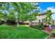 Landscaped backyard features lush green lawn, mature trees, and deck at 10249 Trailriders Dr, Littleton, CO 80125