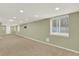 Spacious basement features neutral carpet, recessed lighting, and window at 10249 Trailriders Dr, Littleton, CO 80125