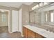 Bathroom showcasing a double vanity, large mirror, and access to a shower and walk in closet at 10249 Trailriders Dr, Littleton, CO 80125