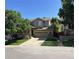 Well-maintained two-story home with a two-car garage, inviting porch, and lush green lawn at 10249 Trailriders Dr, Littleton, CO 80125