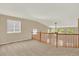 Open loft area with carpet flooring, natural light, and staircase view at 10249 Trailriders Dr, Littleton, CO 80125