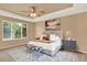 This is a spacious primary suite with tray ceilings, neutral walls, and great natural light at 10249 Trailriders Dr, Littleton, CO 80125