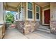 Covered front porch with stone accents, providing a welcoming entrance to the home at 10249 Trailriders Dr, Littleton, CO 80125