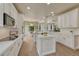 Bright kitchen features white cabinets, center island, modern appliances and wood floors at 15886 E Stargazer Ln, Parker, CO 80134