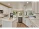 Bright kitchen with sleek white cabinetry, modern appliances, island, and hardwood floors at 15886 E Stargazer Ln, Parker, CO 80134