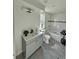 Well-lit bathroom with a gray vanity, modern fixtures, and tiled shower/tub combo at 9036 Mandel St, Denver, CO 80260