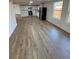 Open-concept living room featuring new wood flooring, and updated kitchen at 9036 Mandel St, Denver, CO 80260