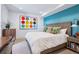Stylish bedroom featuring a queen-sized bed, modern art, and calming blue accent wall at 2539 E 5Th Ave, Denver, CO 80206