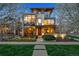 Contemporary home with large windows, stone accents, and landscaped front yard at dusk at 2539 E 5Th Ave, Denver, CO 80206