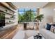 Inviting living room with hardwood floors, custom shelving, and a large window offering great natural light at 2539 E 5Th Ave, Denver, CO 80206