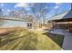 View of a detached garage and a covered back patio from the yard showing the layout of the home at 1355 Hudson St, Denver, CO 80220