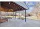 A covered patio with a ceiling fan overlooks a well-kept backyard with detached garage and red chair at 1355 Hudson St, Denver, CO 80220