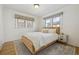 Comfortable bedroom boasts natural light, neutral color palette, and hardwood floors at 1355 Hudson St, Denver, CO 80220