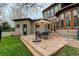 Backyard patio with outdoor seating, steps to the grassy yard, and a view of the home's exterior at 2931 S Cook St, Denver, CO 80210