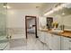 Elegant bathroom showcasing a soaking tub, double sinks, and access to bedroom at 2931 S Cook St, Denver, CO 80210