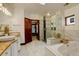 Luxurious bathroom featuring a marble tub, glass shower, and granite countertops at 2931 S Cook St, Denver, CO 80210