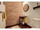 Unique half-bathroom featuring a brick wall and a wooden vanity with a decorative mirror at 2931 S Cook St, Denver, CO 80210