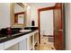 Well-lit bathroom with dark countertops and a classic vanity with white decorative details at 2931 S Cook St, Denver, CO 80210