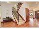 Spacious foyer features stairs with an iron railing, hardwood flooring, and wood-trimmed doors at 2931 S Cook St, Denver, CO 80210