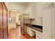 Bright kitchen featuring stainless steel refrigerator, adjacent desk area, and hardwood floors at 2931 S Cook St, Denver, CO 80210