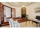 Home office featuring a stone fireplace, glass desk, decorative doors and a comfortable striped chair at 2931 S Cook St, Denver, CO 80210