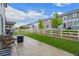 Private backyard with artificial turf, patio, white fence, and views of neighboring homes at 5223 Gray Wolf Ln, Castle Rock, CO 80104