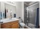 Bright bathroom featuring a shower with glass doors, and a vanity with a large mirror at 5223 Gray Wolf Ln, Castle Rock, CO 80104