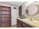 The bathroom features an oval mirror, vinyl floors and built in shelving at 6400 E Mississippi Ave, Denver, CO 80224