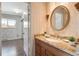 Cozy bathroom features a granite countertop, oval mirror and decorative wallpaper at 6400 E Mississippi Ave, Denver, CO 80224