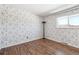 This bedroom has laminate floors, white trim, and a charming floral wallpaper at 6400 E Mississippi Ave, Denver, CO 80224