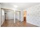 Bedroom features a mirrored closet, vinyl floors and floral wallpaper at 6400 E Mississippi Ave, Denver, CO 80224