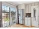 Bright kitchen with stainless steel refrigerator, white cabinets, granite counters, and a view of the backyard at 6400 E Mississippi Ave, Denver, CO 80224