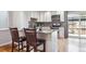 Modern kitchen with white cabinetry, granite countertops, and a breakfast bar, with access to the outdoor patio at 6400 E Mississippi Ave, Denver, CO 80224