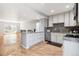 Open-concept kitchen featuring white cabinets, granite countertops, stainless steel appliances, and wood flooring at 6400 E Mississippi Ave, Denver, CO 80224