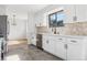 Charming kitchen features ample white cabinets, a stone backsplash, and stainless appliances at 7351 S Marion St, Centennial, CO 80122
