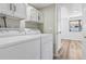 Bright laundry room features updated white cabinets and a modern washer and dryer at 7351 S Marion St, Centennial, CO 80122