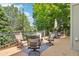 Wooden deck with patio furniture and string lights, surrounded by lush trees at 775 Poppywood Dr, Highlands Ranch, CO 80126
